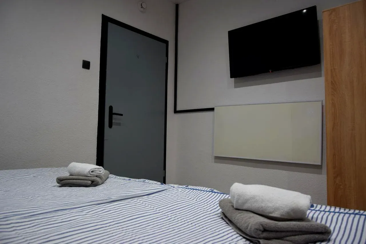 Schlafzimmer mit Doppelbett, Fernseher und Kleiderschrank