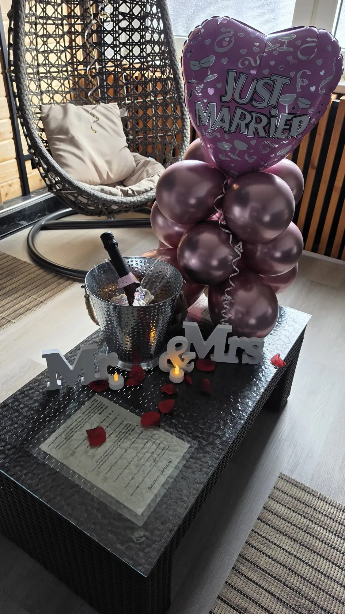 Sektkühler, Mr-und-Mrs-Schriftzug und Just-Married-Ballons auf dem Tisch
