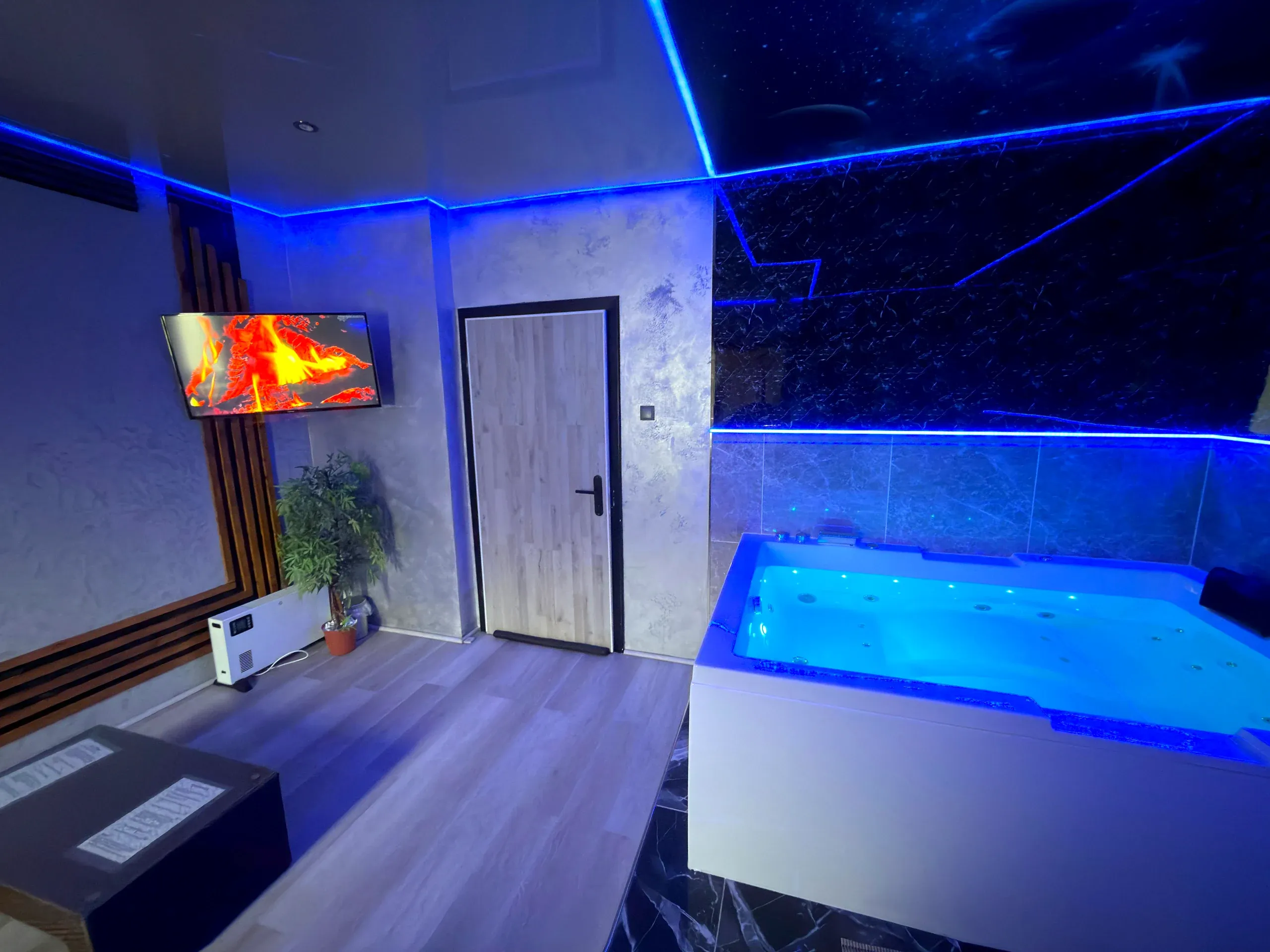 Whirlpool der Wellness Suite Gelsenkirchen mit blauer LED-Beleuchtung und Sternenhimmel-Decke
